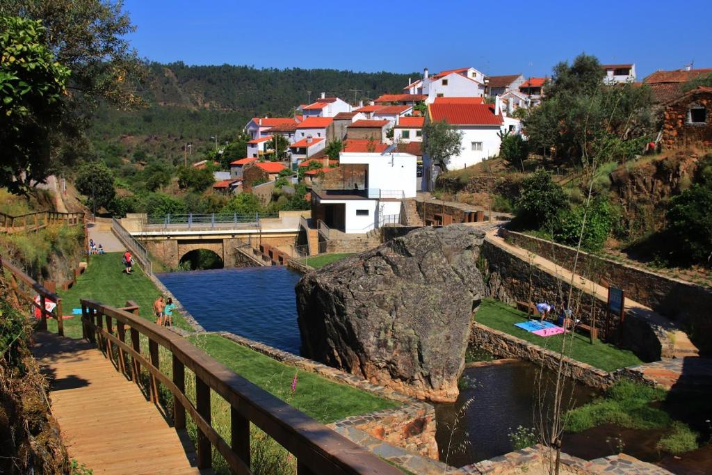 un pont sur une rivière avec une ville en arrière-plan dans l'établissement A Casa da Lena, à Foz do Cobrão