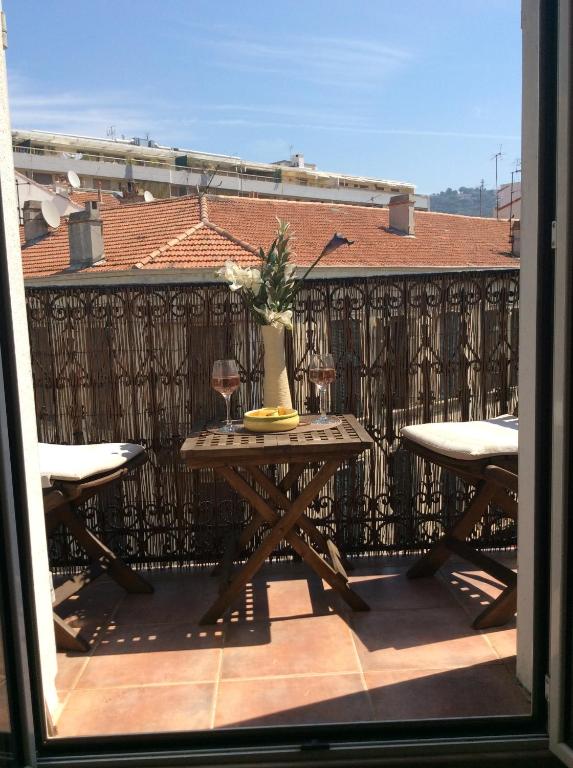 une table avec un vase sur le balcon dans l'établissement Lecerf apartment, à Cannes