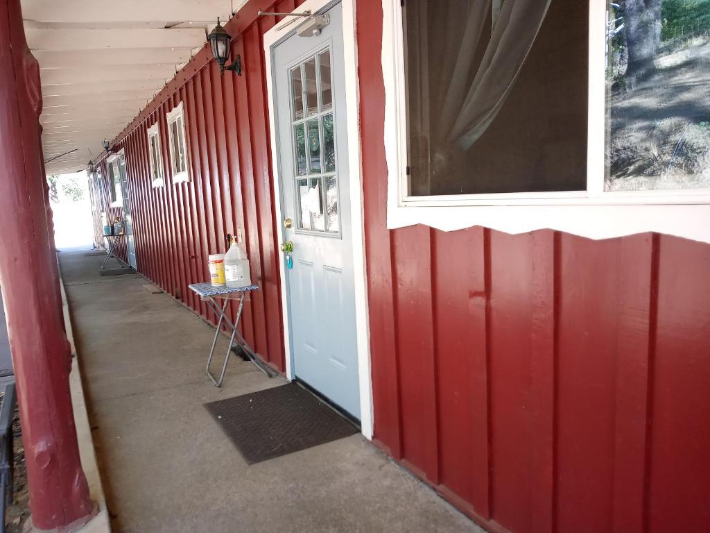 a red building with a red wall and a white door at Yosemite Paradise Inn in Coulterville