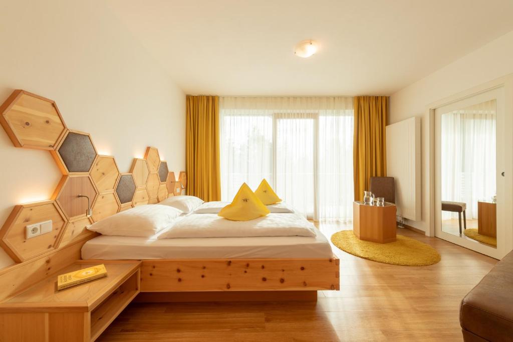 sypialnia z dużym łóżkiem z drewnianym zagłówkiem w obiekcie APIPURA hotel rinner w mieście Soprabolzano