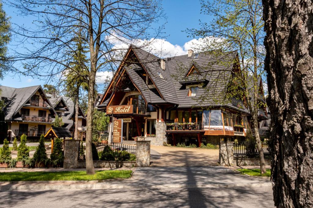 une grande maison avec un toit en gambrel dans l'établissement Hotel Willa Pod Skocznią, à Zakopane