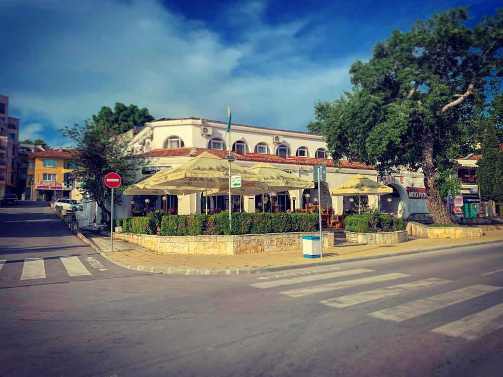 a building with umbrellas on the side of a street at Sea Square Hotel in Balchik