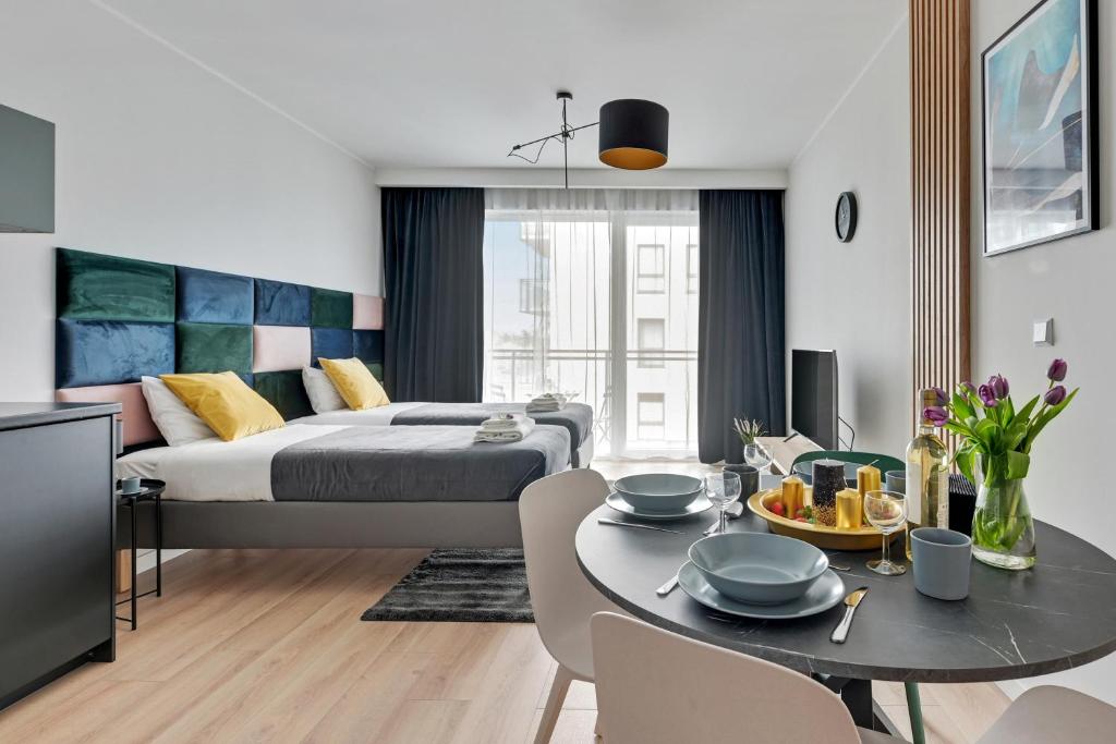 1 dormitorio y sala de estar con 1 cama y 1 mesa en Apartament Wałowa Stara Stocznia Gdańsk en Gdansk