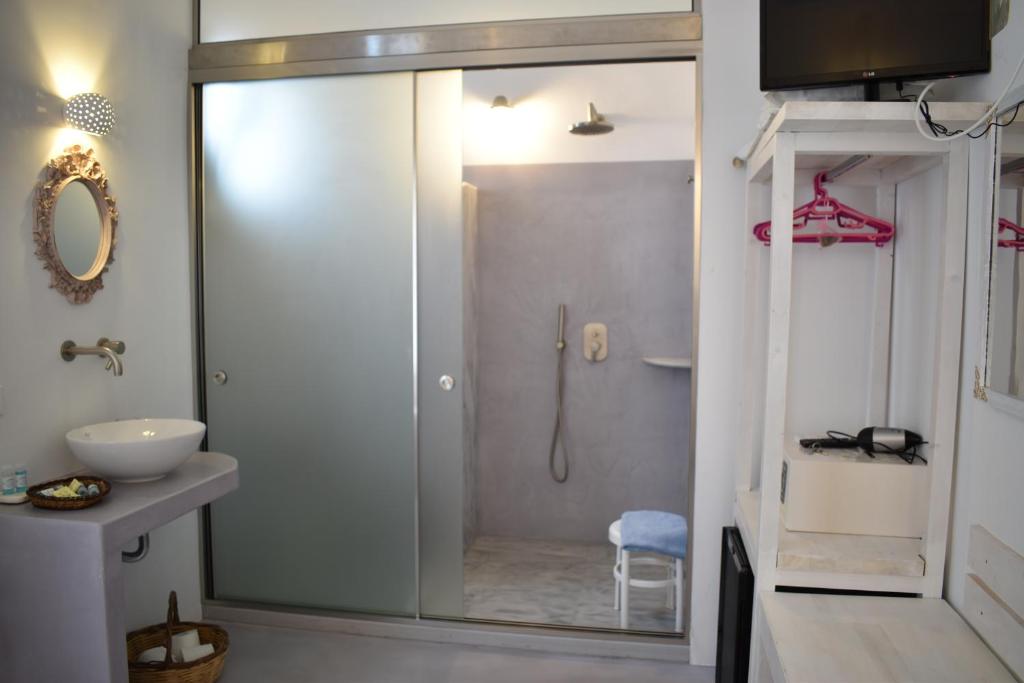 y baño con ducha y puerta de cristal. en Andriani's Guest House, en Mykonos ciudad