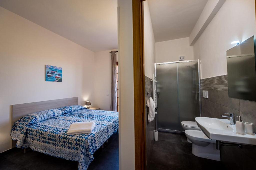 a bathroom with a bed and a sink and a shower at Villa Michelangelo in Castellammare del Golfo