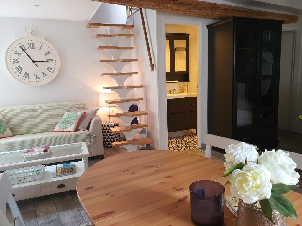 un salon avec une horloge et un escalier en colimaçon dans l'établissement Traverse du Vieux Château, à Menton