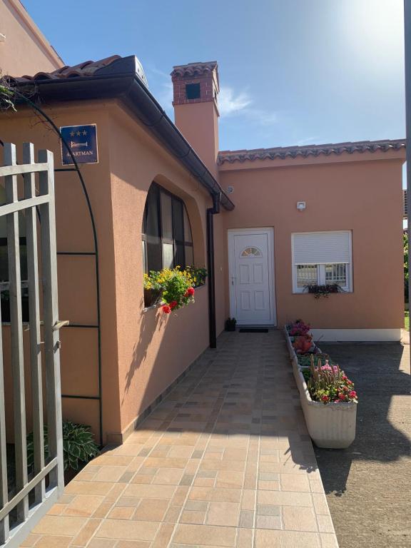 a house with a driveway and a white door at Apartman Dalija in Vinkuran