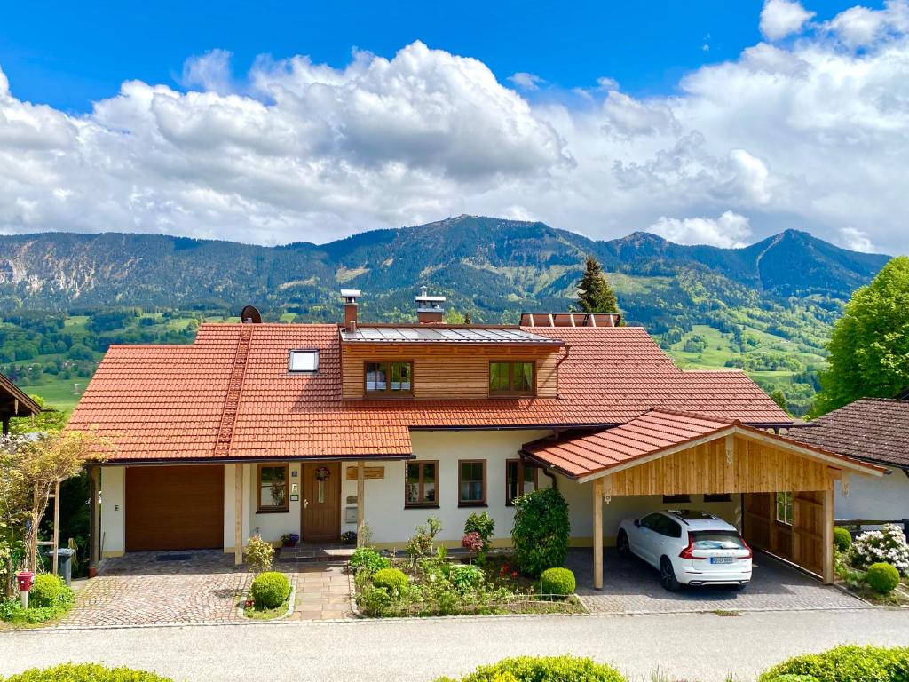 une maison avec une voiture garée devant elle dans l'établissement Apartment Sonnenfeld, à Samerberg