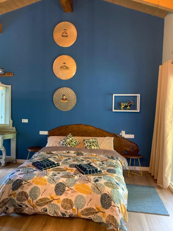 a bedroom with a blue wall with a bed at El Habar de Pria in La Pesa
