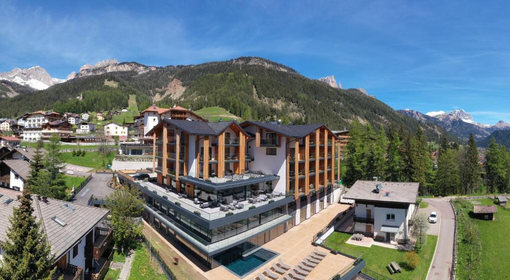 an aerial view of a building with mountains in the background at Ciampedie Luxury Alpine Spa Hotel in Vigo di Fassa