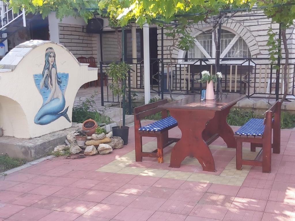 a table and chairs with a painting of a mermaid at Villa Bela in Balchik