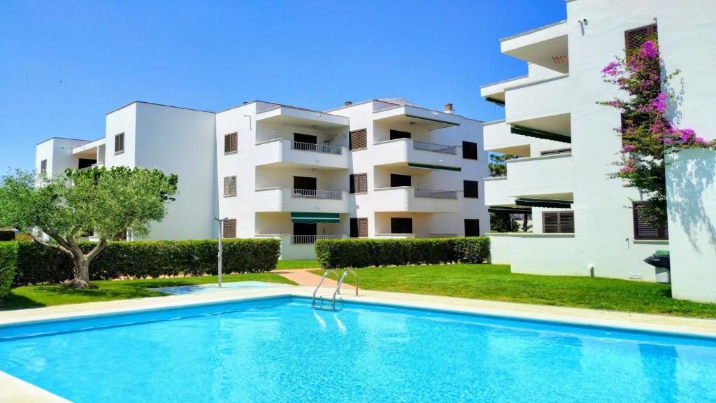 un appartement avec une piscine en face d'un bâtiment dans l'établissement VACAY Apartamento Tras, a 100m de la playa, à L'Escala