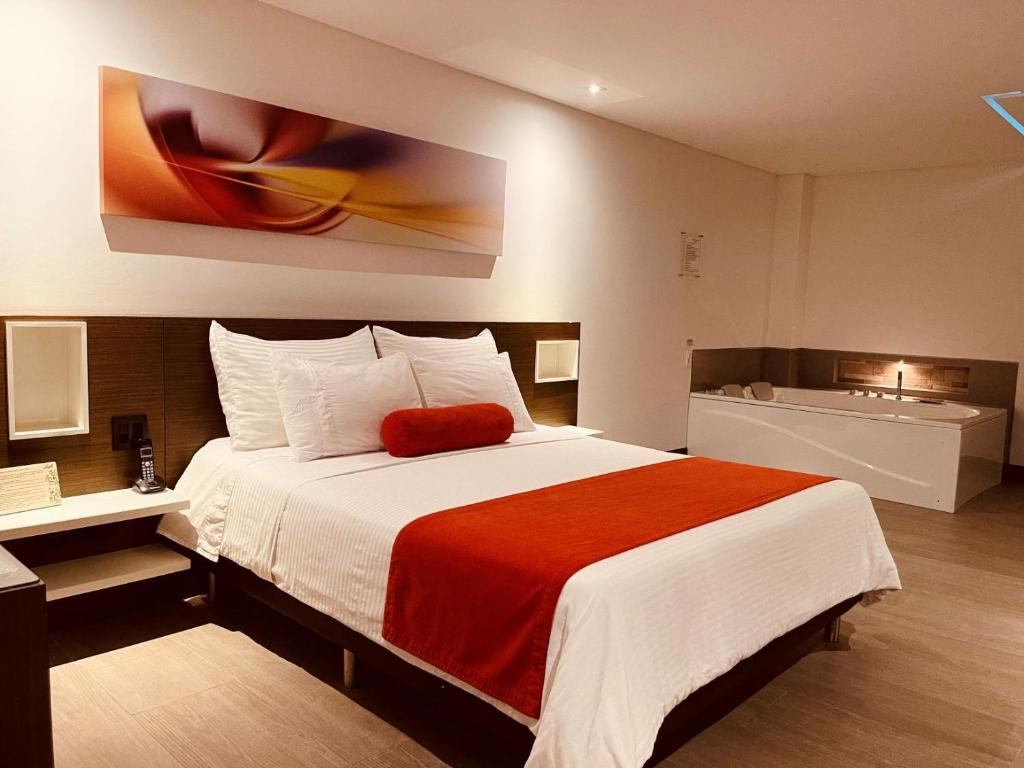 a bedroom with a large bed with a red blanket at Hotel Loyds in Medellín