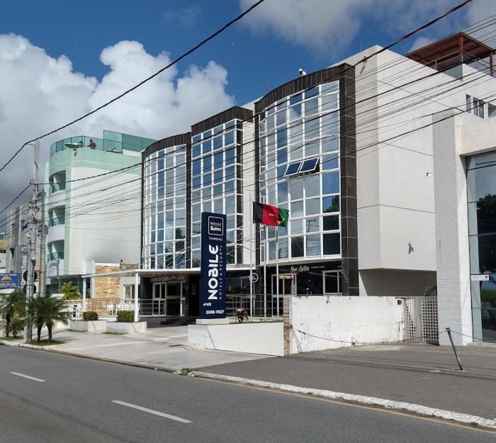 un gran edificio en una calle de la ciudad con un semáforo en AP 306 Flat Beira mar praia de Tambaú, en João Pessoa