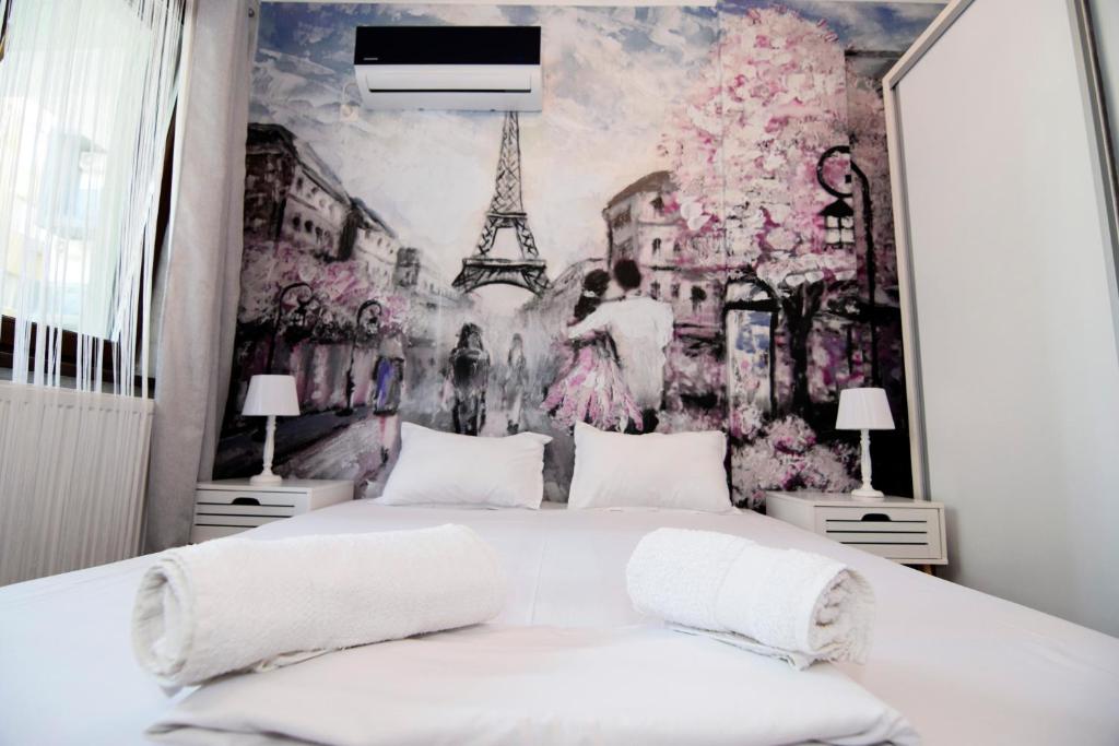 um quarto com uma cama grande e um mural da Torre Eiffel. em Ioana Studio Mamaia Nord em Mamaia Nord – Năvodari