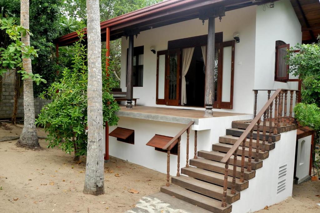 a house with a staircase in front of it at The Waves Beach Chalets in Tangalle