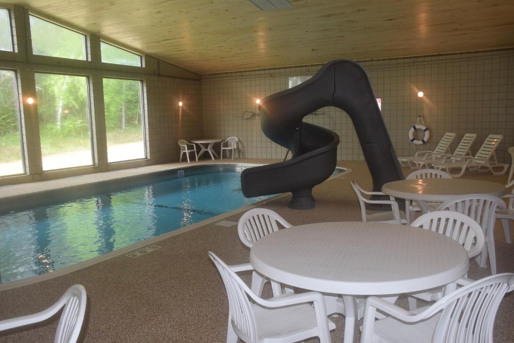 uma piscina com escorrega numa sala com mesas e cadeiras em Walker Hotel em Walker