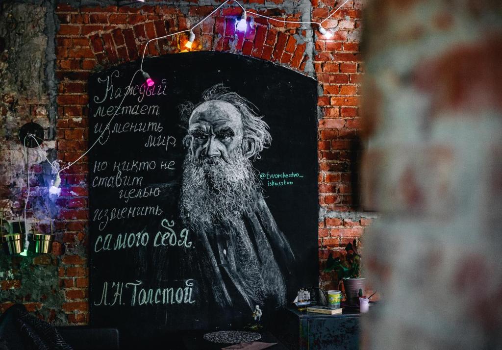 a sign on a brick wall with a man with a beard at Tolstoy Art-Hostel in Kaliningrad