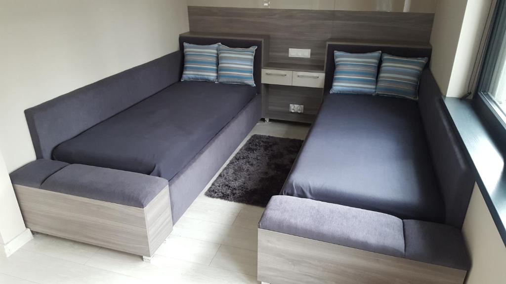 um quarto com duas camas e um banco em Comfort Villa em Pobierowo