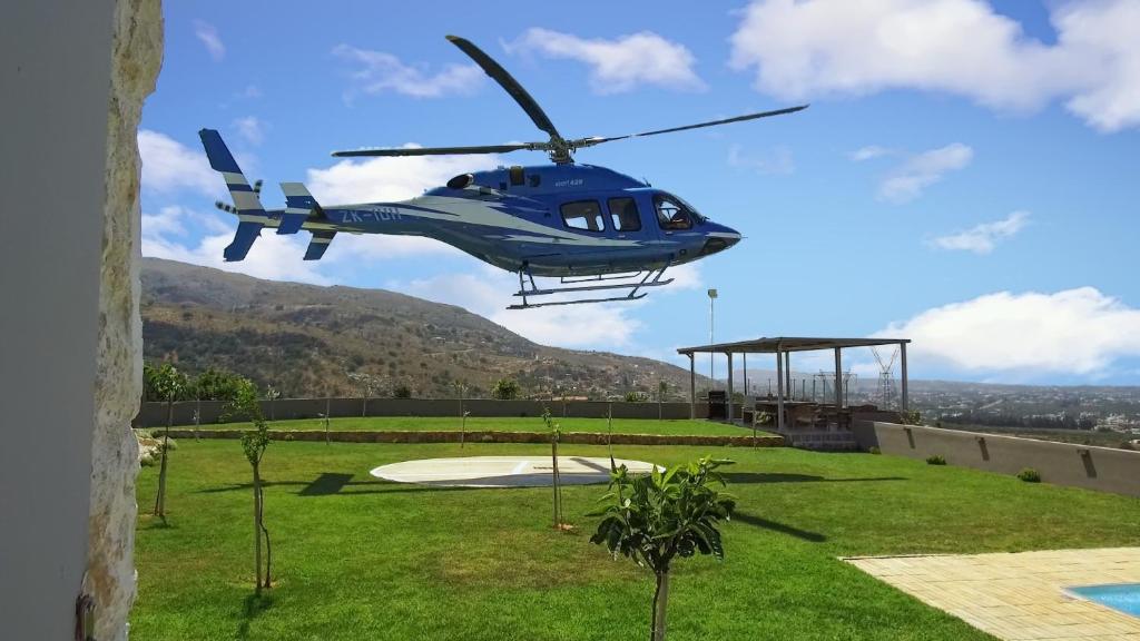 ソウダにあるVilla Kedria with a panoramic ocean viewの青いヘリコプターが飛び立っている