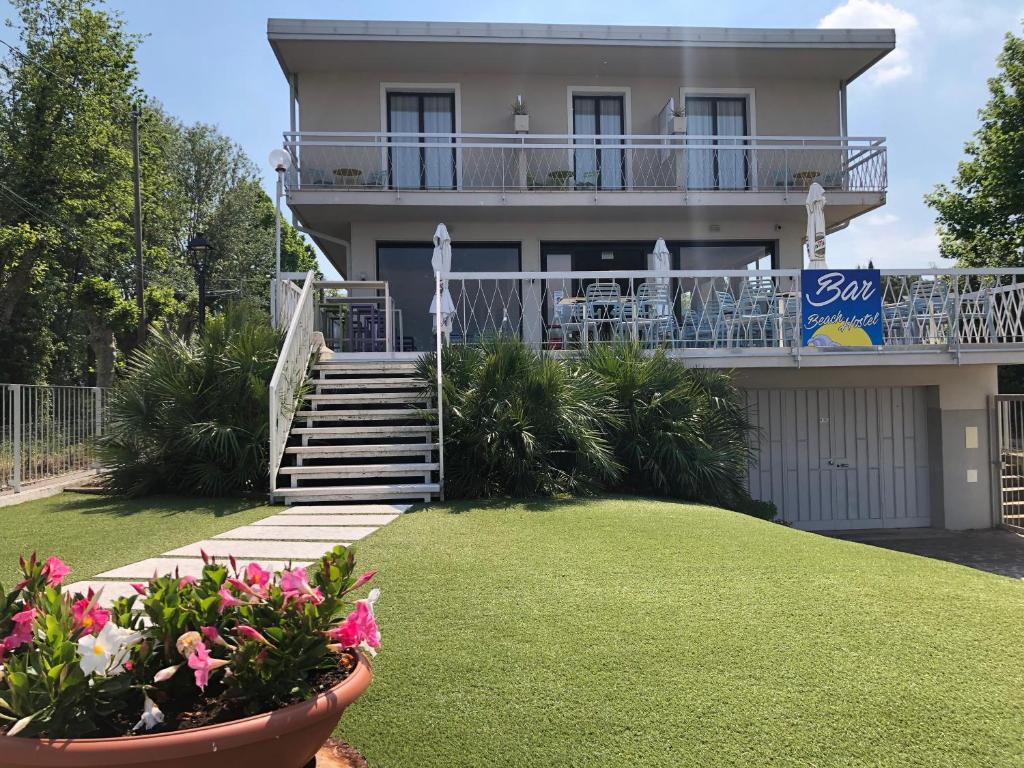 een huis met een trap en bloemen in een tuin bij Lake Garda Beach Hostel in Padenghe sul Garda