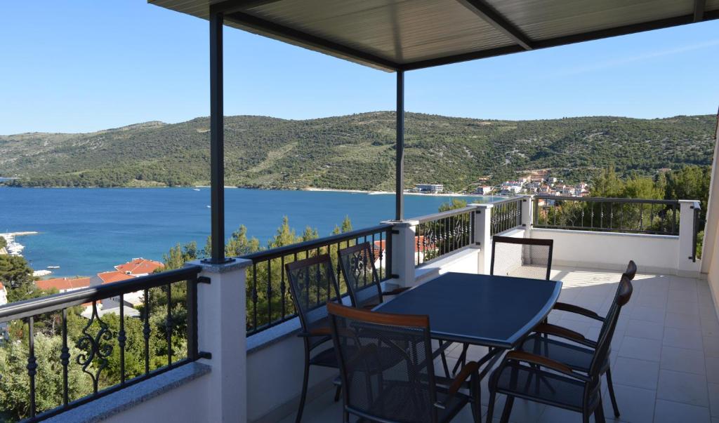 einen Balkon mit einem Tisch und Stühlen sowie Blick auf das Wasser in der Unterkunft Apartman Toni&Luka in Marina