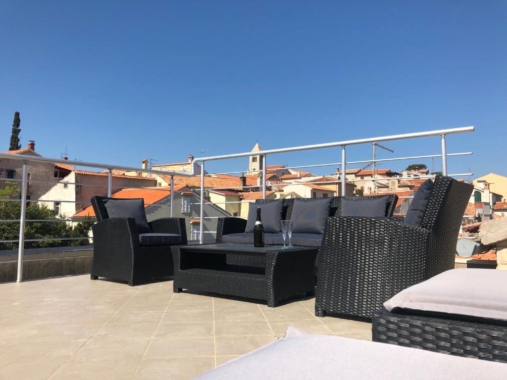 a patio with chairs and a table on a balcony at Apartments Ivana Rab in Rab