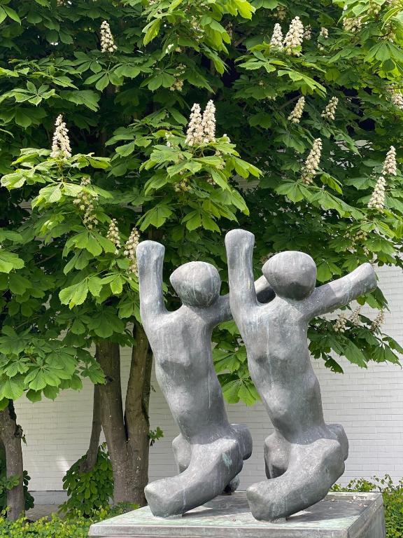 a statue of two people with their arms in the air at vakantiehuis Cerise, Luxueus genieten in de Leiestreek in Deinze