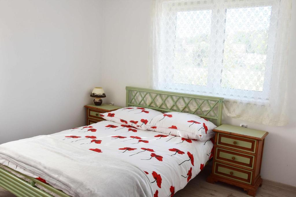 a bedroom with a bed with red fish pillows at W Ziołowym Ogrodzie - pokoje z dostępną kuchnią, apartament in Kudowa-Zdrój