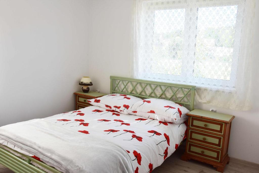 1 dormitorio con 1 cama con almohadas de pescado rojo en W Ziołowym Ogrodzie - pokoje z dostępną kuchnią, apartament, en Kudowa-Zdrój