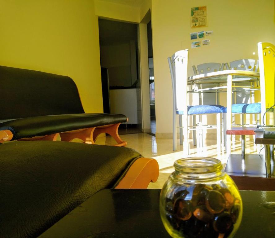 a living room with a couch and a table with a glass jar at Apartamentos Casa MJ Tunja in Tunja