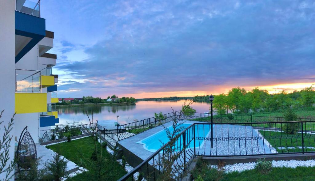 uma vista para um corpo de água com uma piscina em Snagov Lakeview Residences em Tîncăbeşti