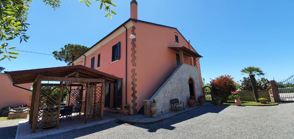 a small pink building with a tower on top at Appartamento Colle Mezzano in Cecina