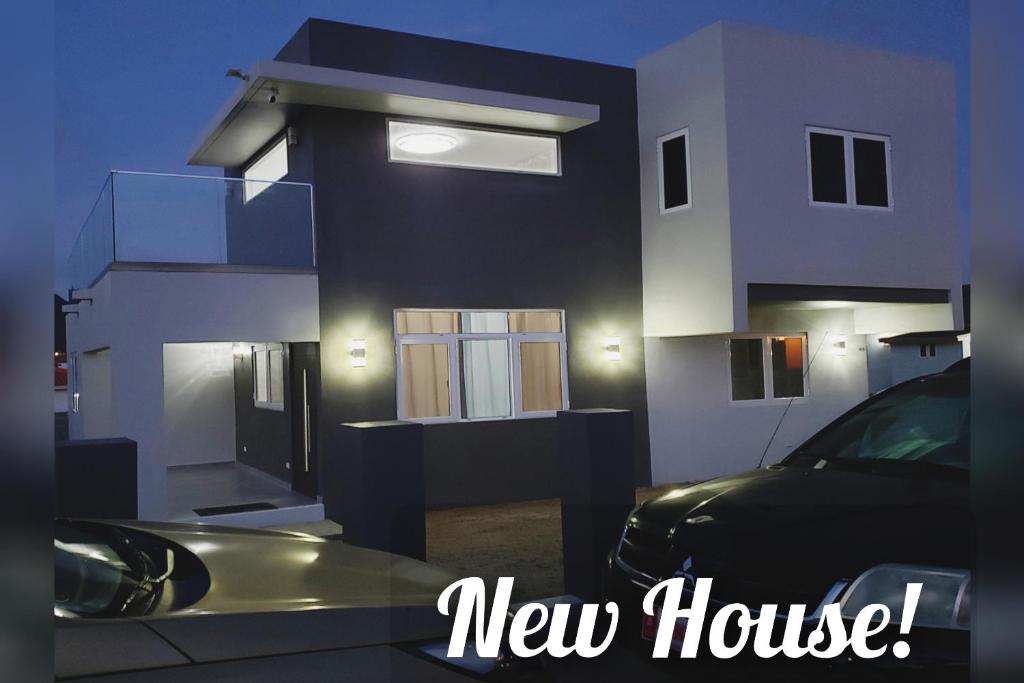 una casa nueva con un coche aparcado delante de ella en Aruba Vacation House - Cozy and Modern!, en Oranjestad