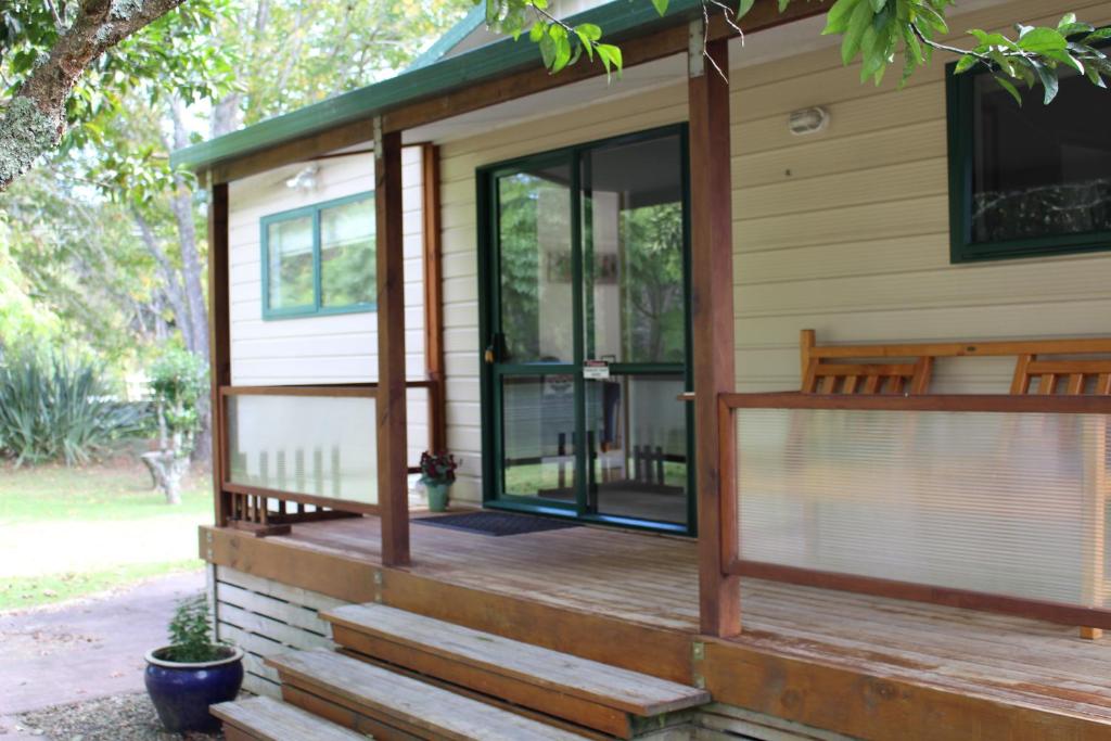 a screened porch with glass doors on a house at Parsloe's Cottage in Coromandel Town