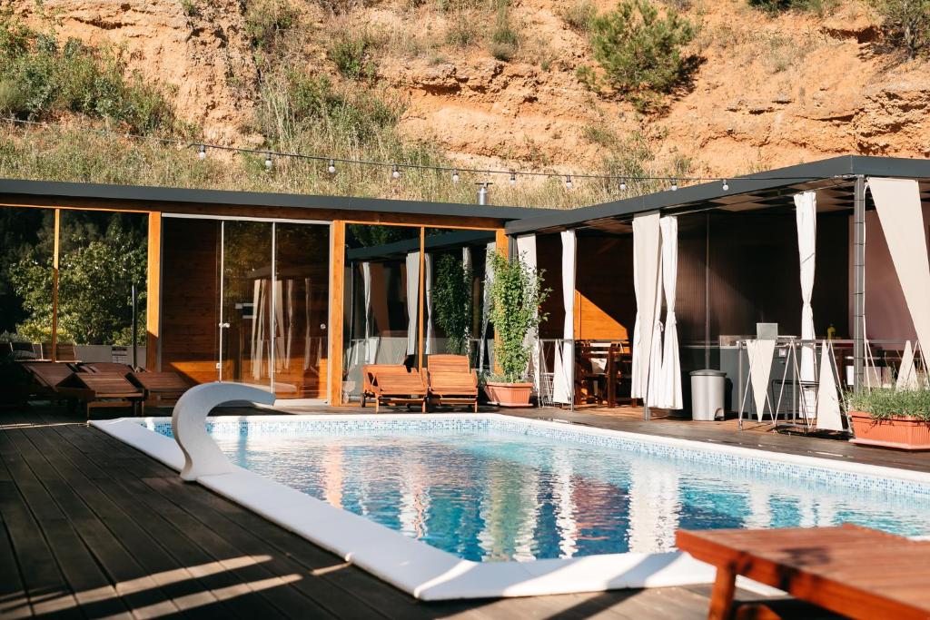 a house with a swimming pool next to a mountain at Illyria Apartments in Skradin