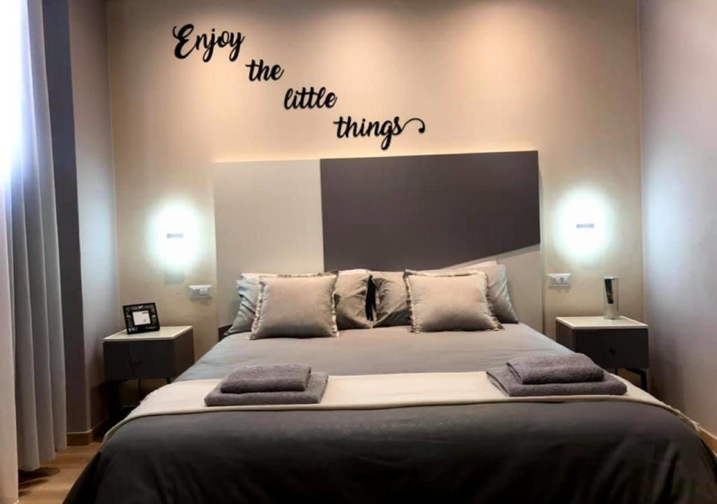 um quarto com uma cama com as palavras desfrutar das pequenas coisas em Room sweet Room 2 em Bolonha