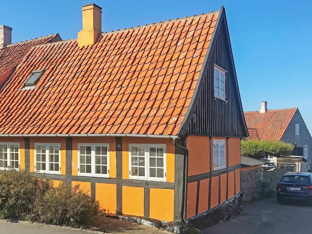 スヴァネケにある3 person holiday home in Svanekeの黄色・橙色の屋根の家
