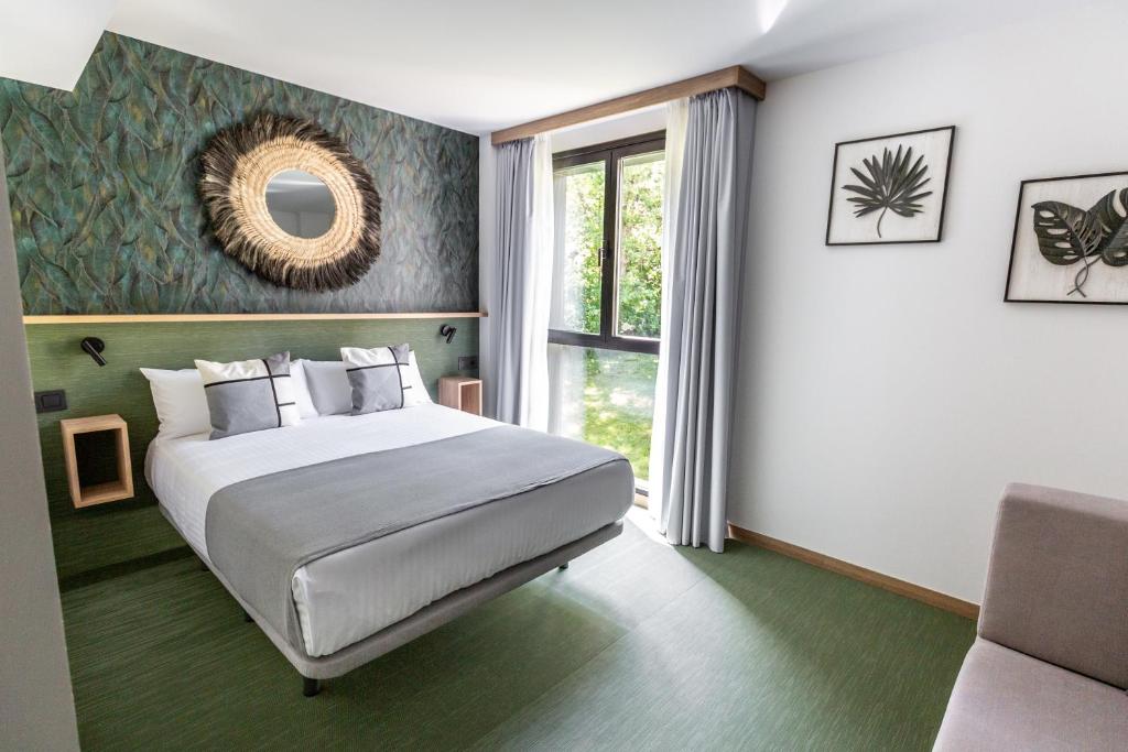 a bedroom with a large bed and a window at Hotel Ecos del Sella in Cangas de Onís