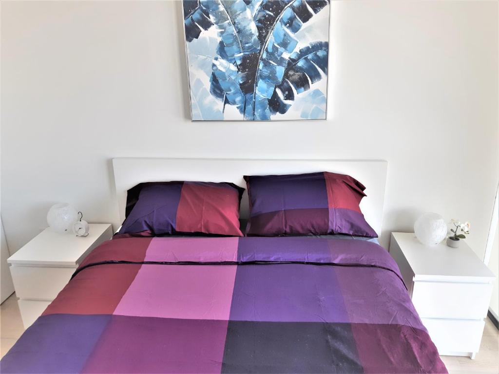 a bedroom with a purple bed with two white tables at Luxury skyline condo in downtown FREE 24/7 parking in Winnipeg