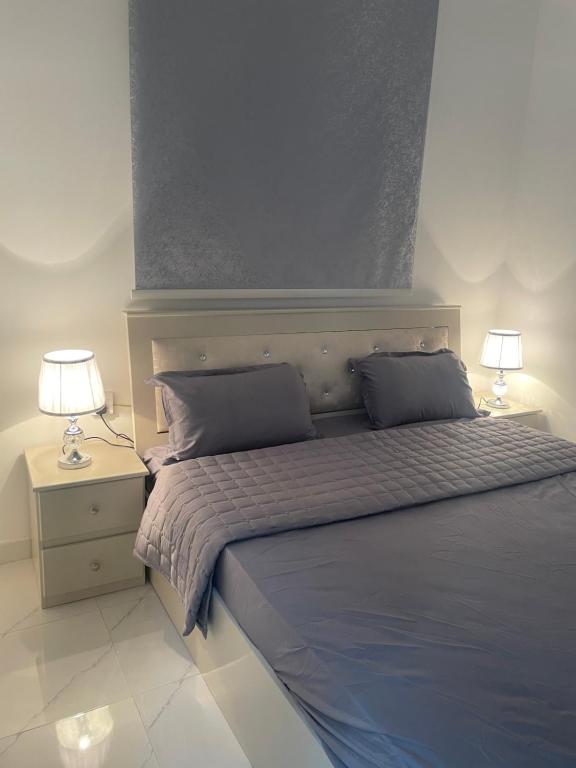 a bedroom with a bed with two lamps on it at رافا للشقق السكنية in Abha