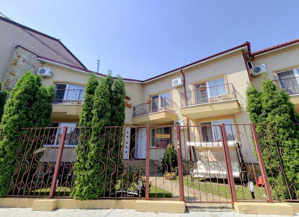 a building with a fence and trees in front of it at Vila Casa Esy in Eforie Nord