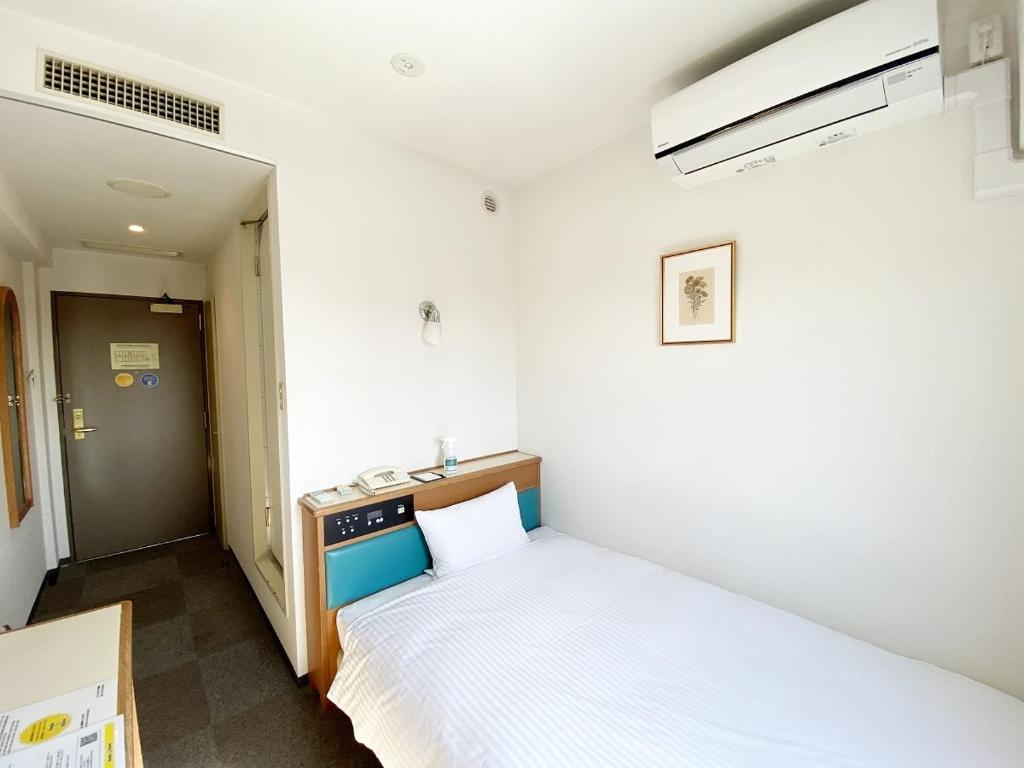 Asaka的住宿－Smile Hotel Kitaasaka，一间小卧室,卧室内配有一张床铺