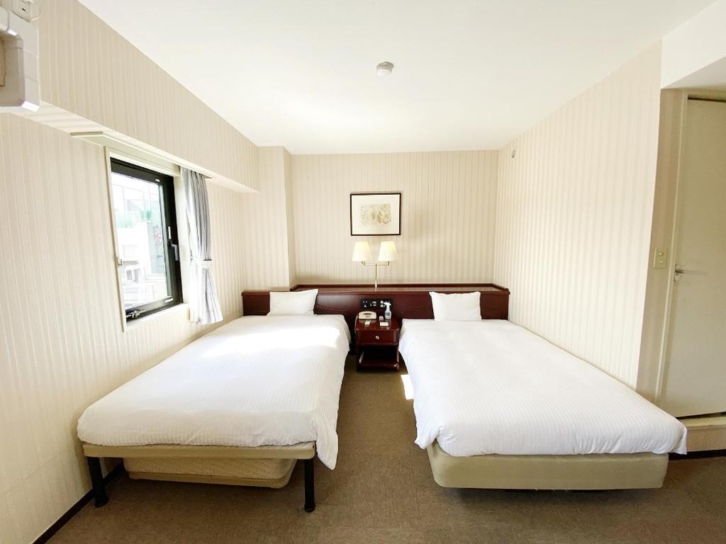 Postel nebo postele na pokoji v ubytování Smile Hotel Kitaasaka