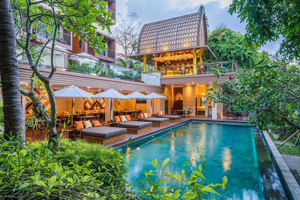 a villa with a swimming pool and a house at Pandawa All Suite Hotel in Seminyak