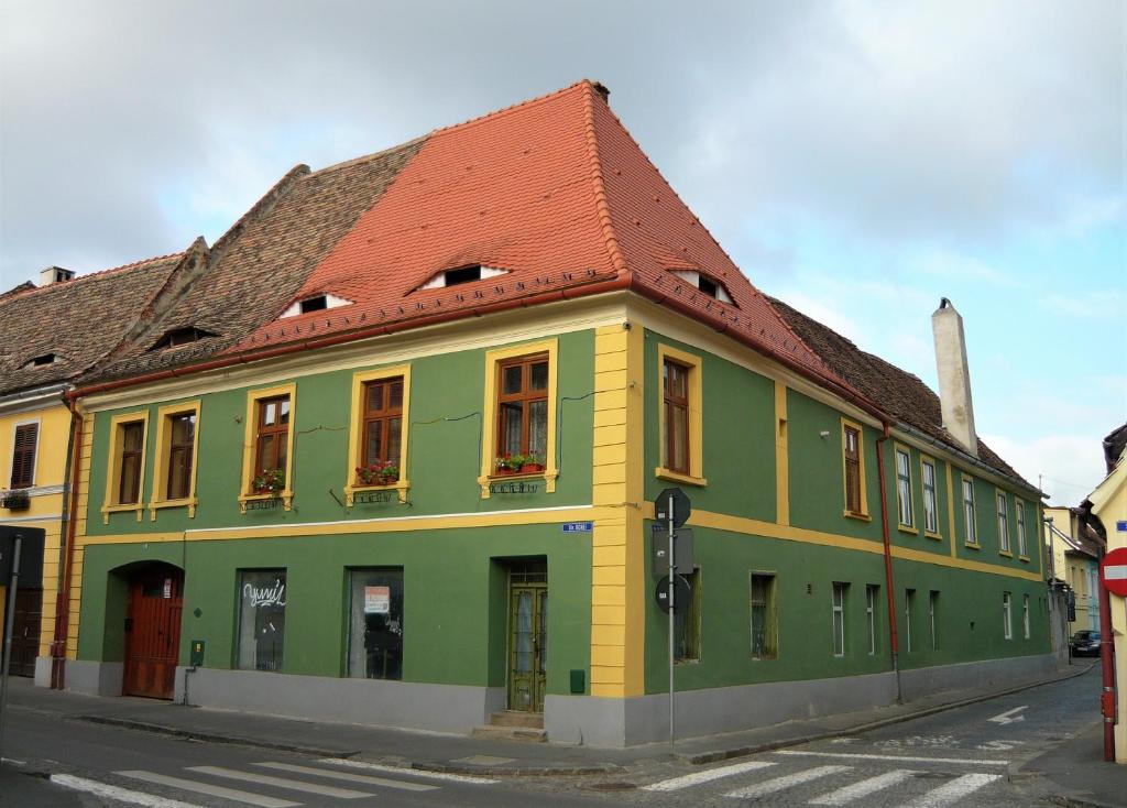 a green and yellow building with a red roof at Sibiu Home 4 Green in Sibiu