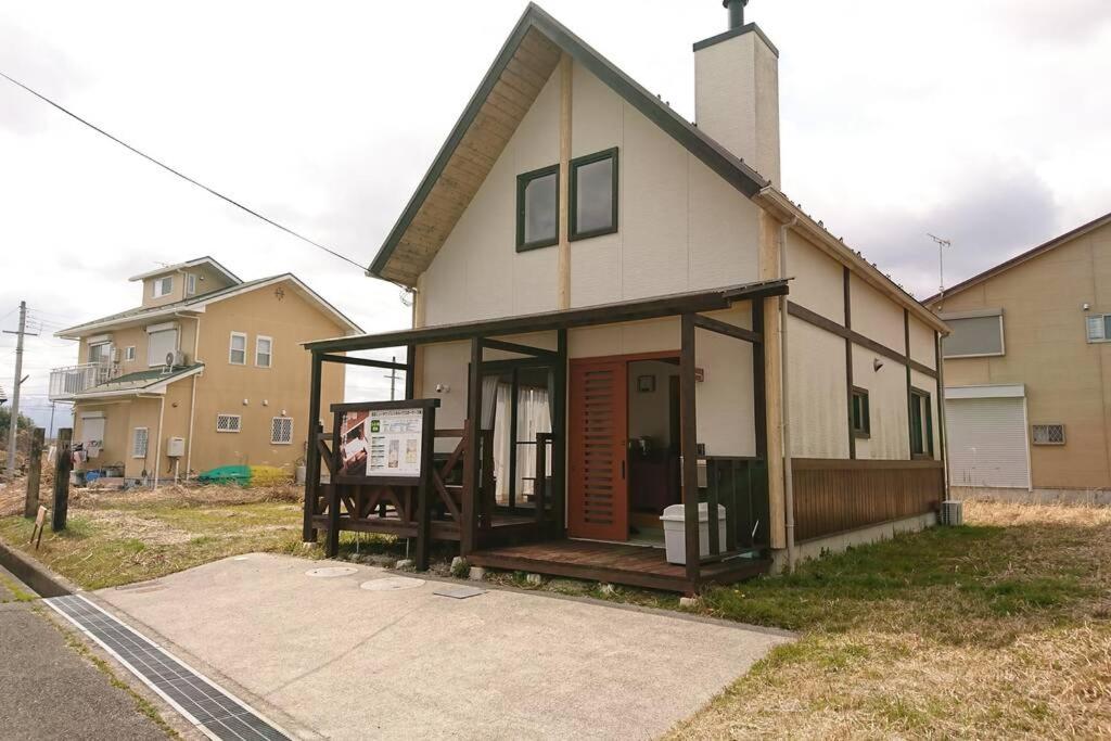 una casa con un porche con un cartel delante en 風車村3-G-1B号棟 en Aiba