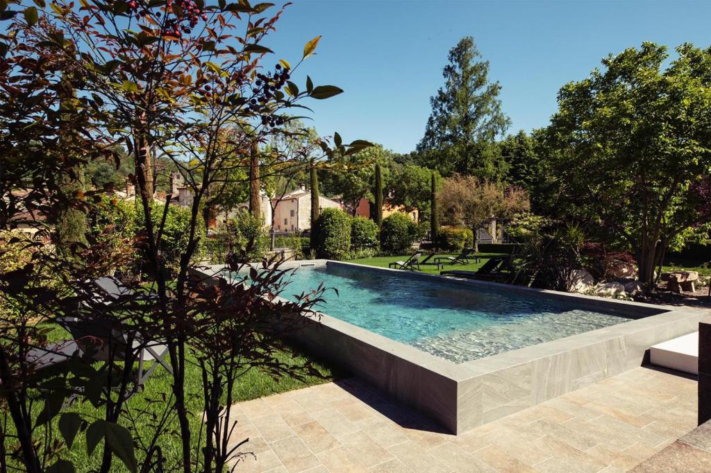 - une piscine dans une cour arborée dans l'établissement Relais Borghetto, à Valeggio sul Mincio