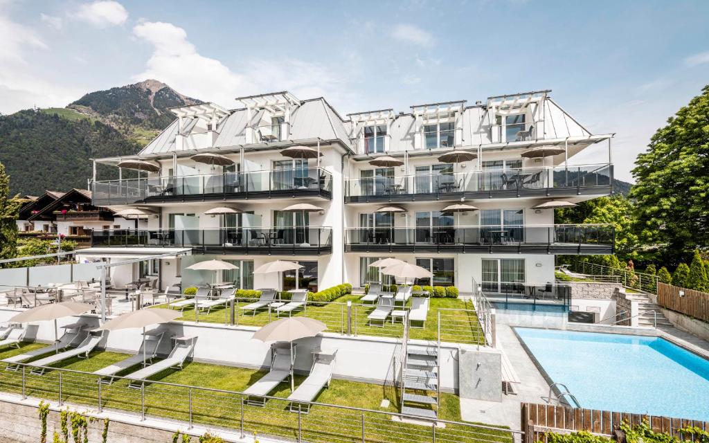 un hotel con piscina y un complejo en AMELIA rooms en Tirolo