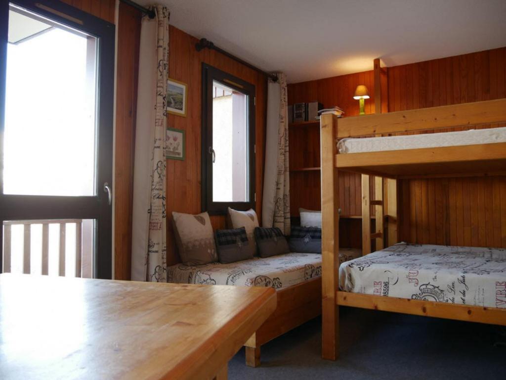 a room with two bunk beds and a table at Studio Bellentre, 1 pièce, 3 personnes - FR-1-329-3 in Bellentre
